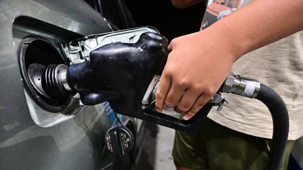 A man pumps gas into a vehicle at a petrol station on October 2, 2023 in Alhambra, California.