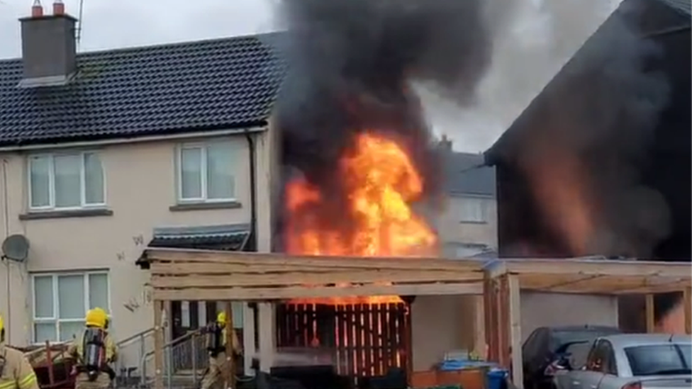 Fire engine extinguishing a shed fire