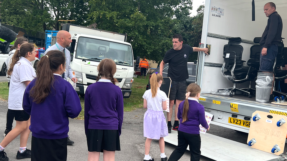 Pupils watching furniture being unloaded