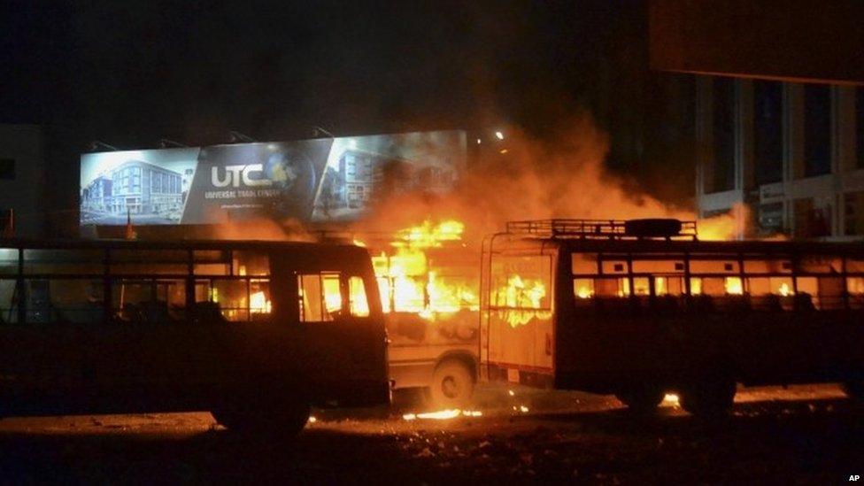 In this late Tuesday, Aug. 25, 2015 photo, passenger buses set on fire by a mob go up in flames in Surat, Gujarat state, India