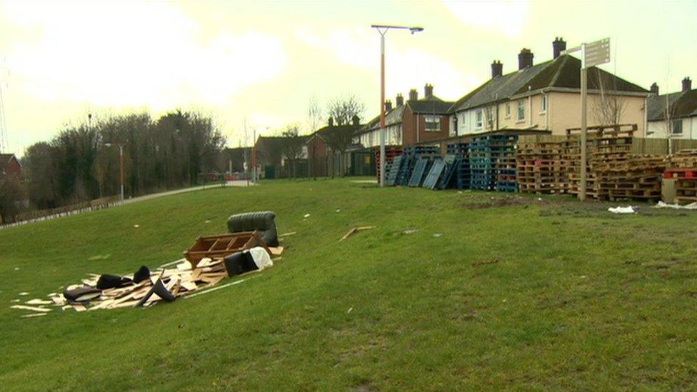 Pallets and rubbish piled near houses