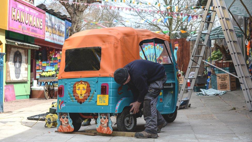Worker puts finishing touches on a rickshaw