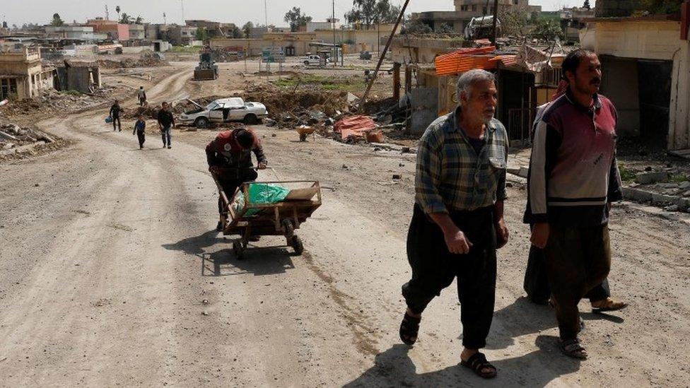 Displaced Iraqis who fled homes carry their belongings during a battle between Iraqi forces and Islamic State militants n Mosul (29 March 2017)