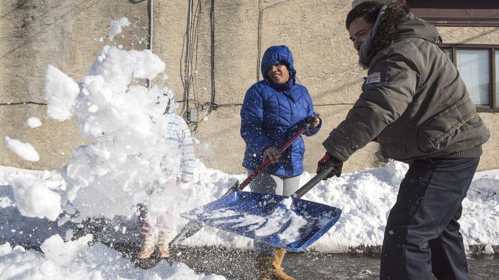 A family shovels snow