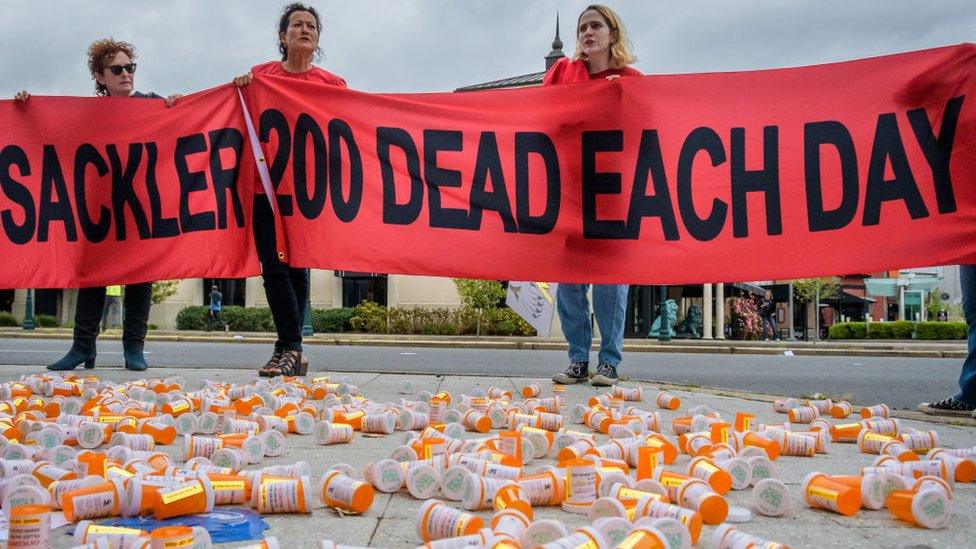 Protesters at Purdue Pharma HQ holding a sign reading: "Sackler 200 dead each day"