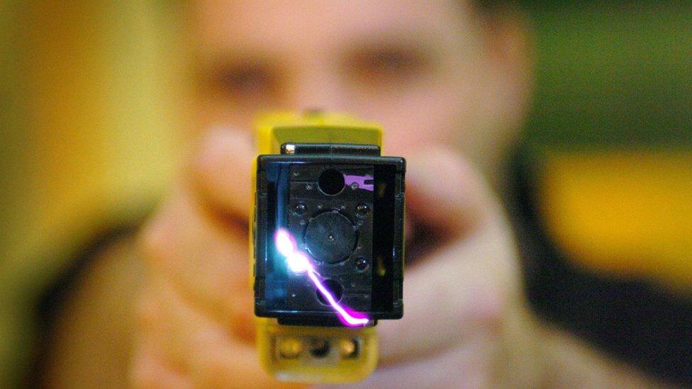 Police officer firing a Taser