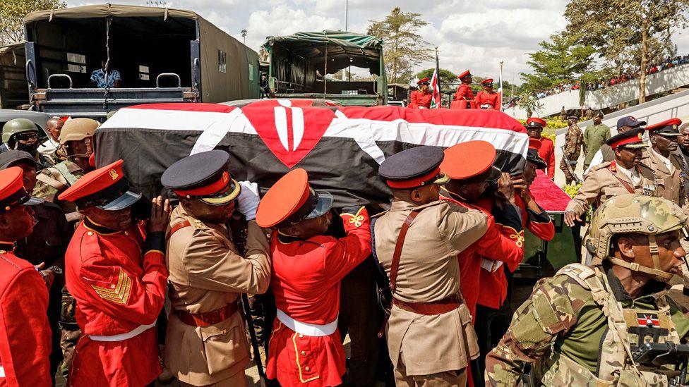 Soldiers and officers dressed in a red uniform carry the coffin of Raila Odinga into a stadium in Nairobi - 16 October 2025
