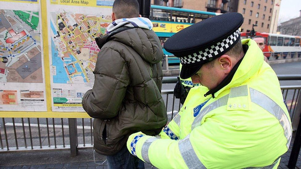 A police officer searches a man