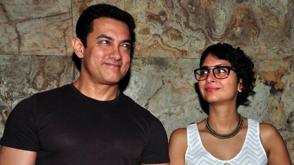 This photograph taken on November 14, 2014, shows Indian Bollywood actor Aamir Khan (L) with his wife Kiran Rao as they attend a screening of the documentary film "After My Garden Grows" in Mumbai.