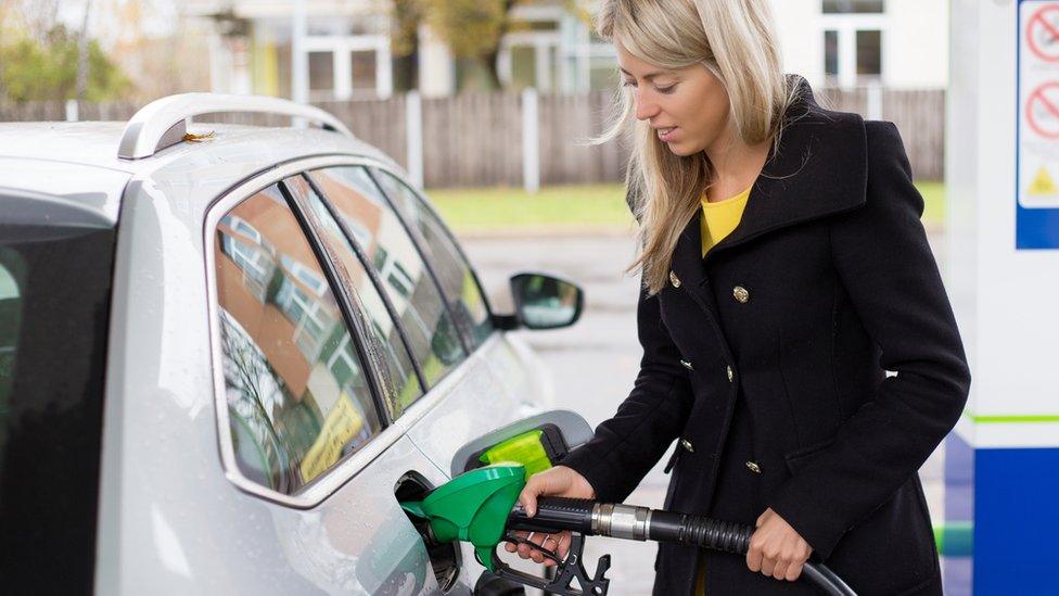 woman filling car with fuel