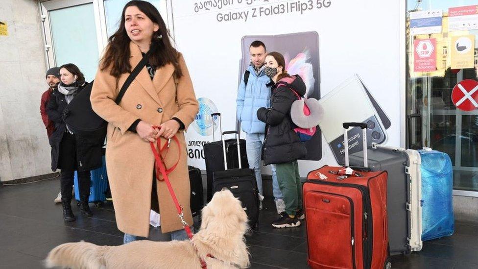 Russians as they wait for a taxi at the airport upon their arrival in Tbilisi on 7 March