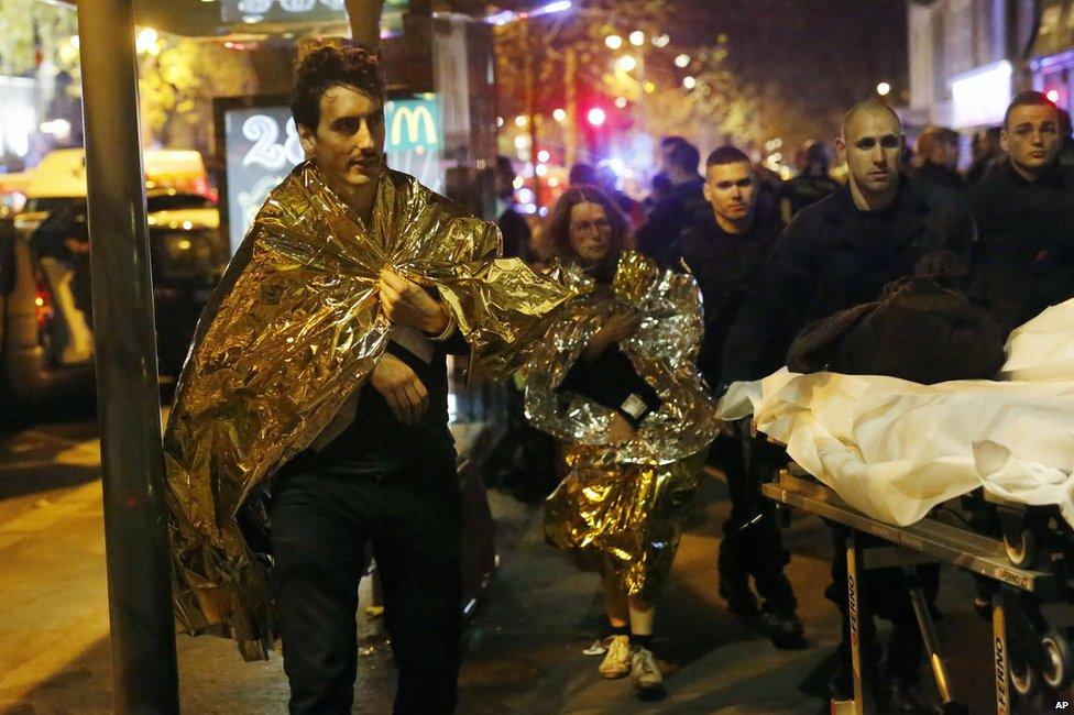 Victims walk away outside the Bataclan theatre in Paris