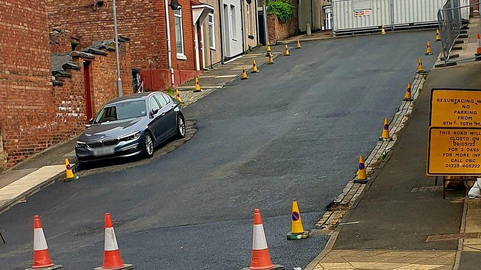 Road resurfaced around parked car