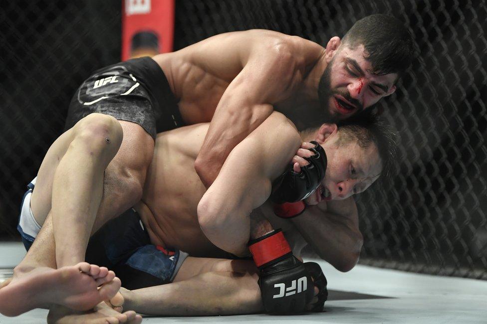 Amir Albazi attempts to secure a rear choke against Zhalgas Zhumagulov of Kazakhstan during the UFC 257 event inside Etihad Arena on 23 January 2021 in Abu Dhabi