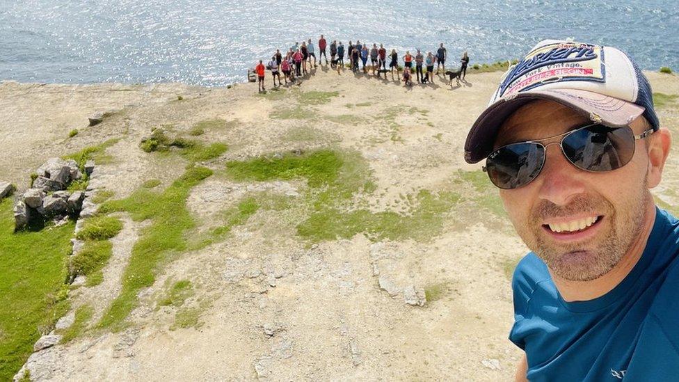 Keith Jones smiling in front of walking group