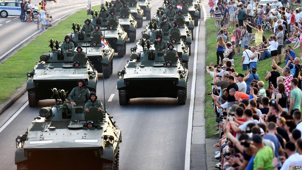 Crowds watch as Croatian soldiers pass atop armoured vehicles on 4 August 2015 in Zagreb, during a military parade to mark the 20th anniversary of Operation Storm