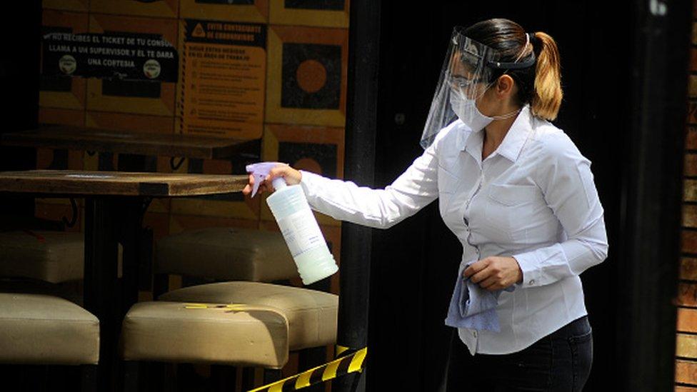 A hostess wears face shield while disinfect a place in a restaurant of Zona rosa in Mexico City