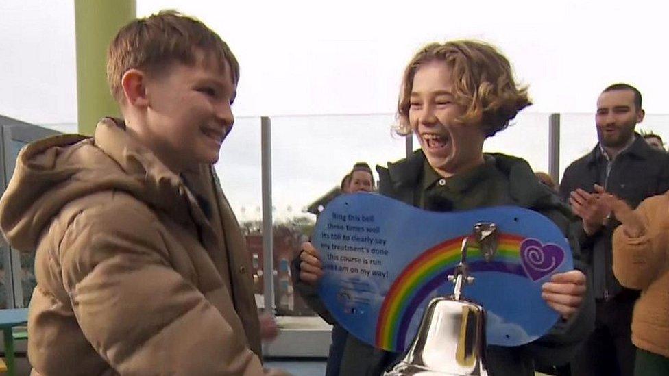 Fundraiser Hughie (left) rings a bell with best friend Freddie alongside him