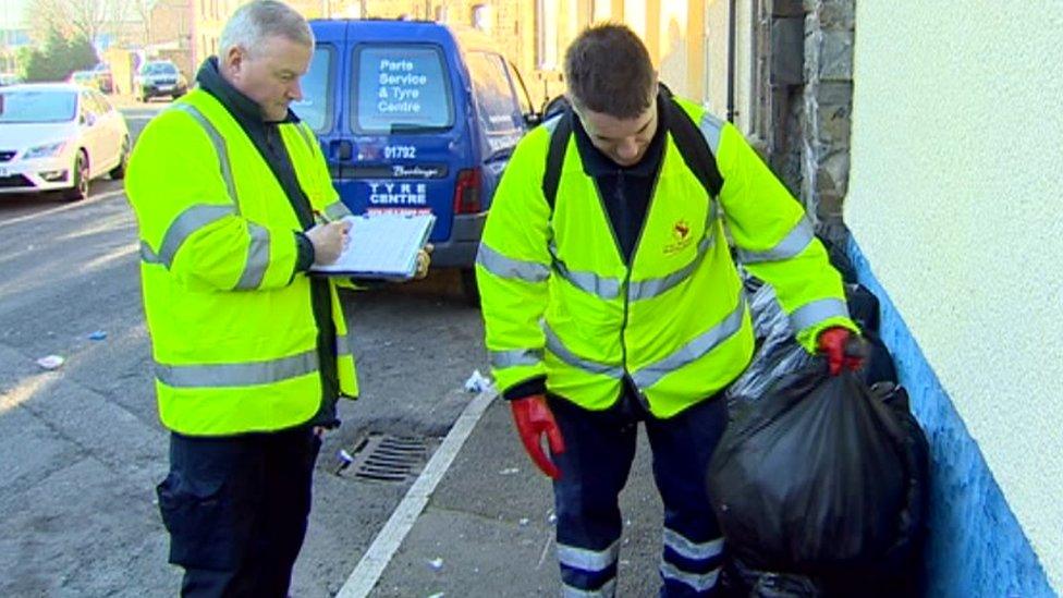 Council workers looking through black bags