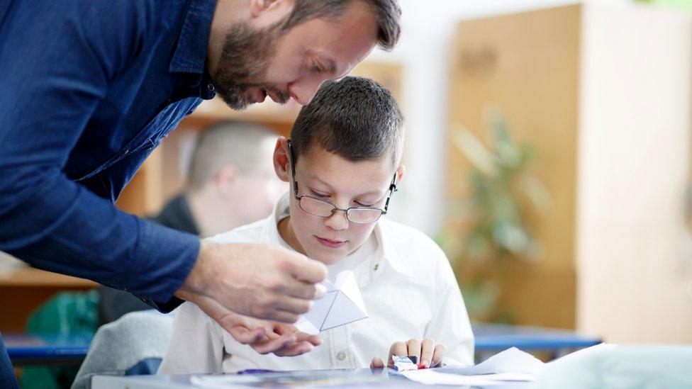 Special education teacher helping pupil