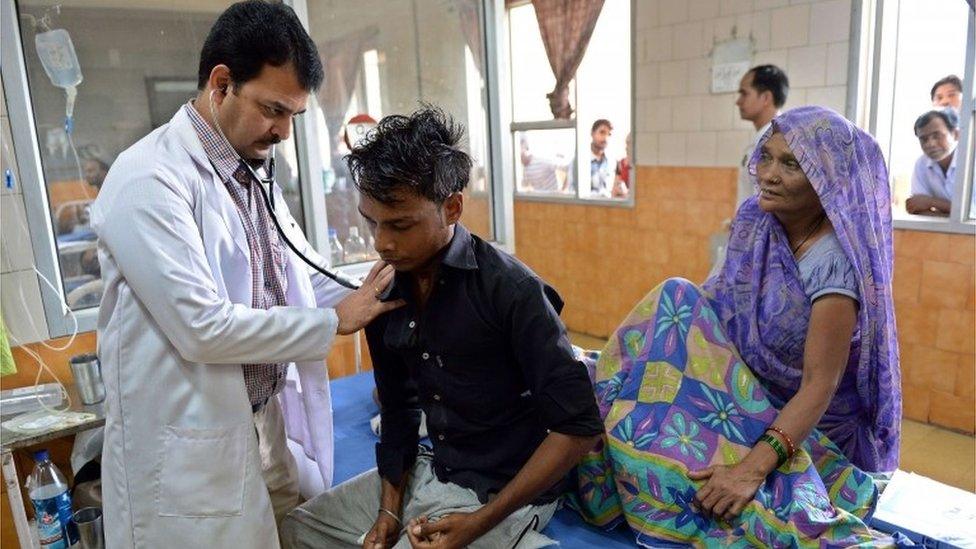 Indian doctor Hemant Sharma (L) checks a dengue patient in The Hindu Rao hospital in New Delhi on September 16, 2015.