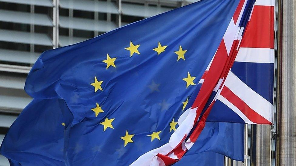 A Union Jack (R) hangs next to European Union flags in front of the European Commission