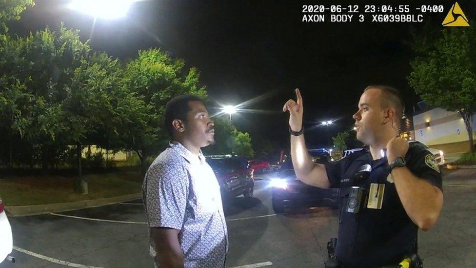 Garrett Rolfe conducts a field sobriety test on Rayshard Brooks in a Wendy's restaurant car park