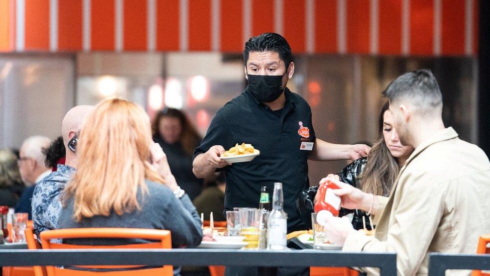 A waiter serves food at a restaurant near Times Square in New York City, U.S., December 16, 2021.