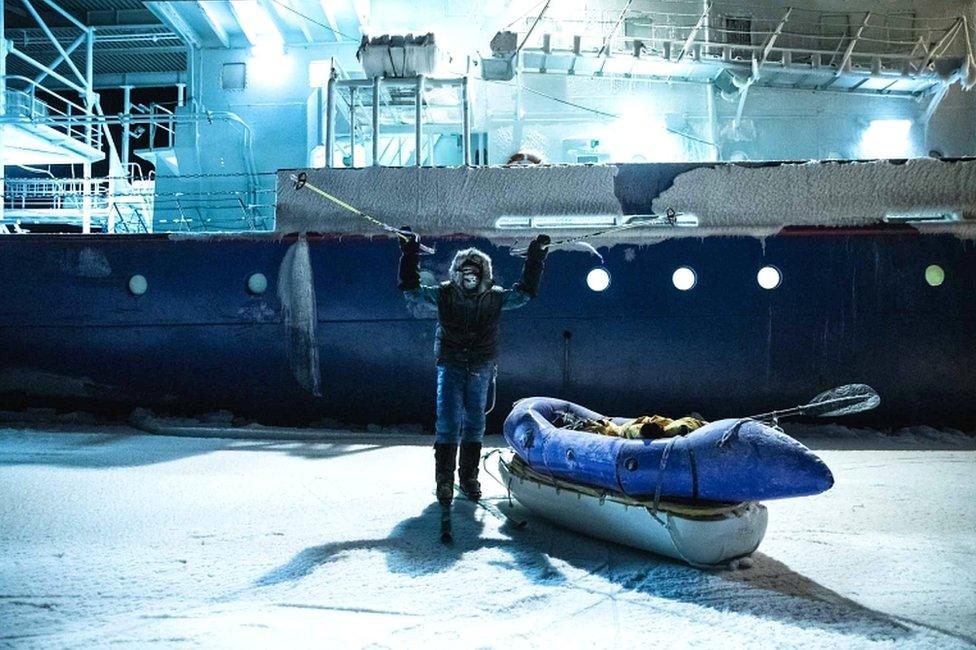 Picture handed out by the Mike Horn Sarl shows South African-born Swiss Mike Horn raising his ski sticks as he poses on 8 December 2019 in front of the Lance icebreaker boat in Norwegian waters of the Arctic Ocean