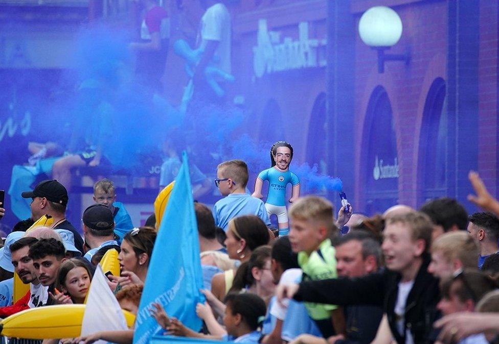 Fan waves an inflatable doll with the face of Manchester City's Jack Grealish