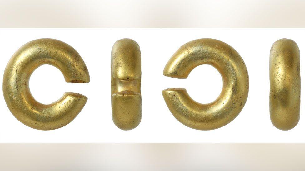 Four views of a Bronze Age gold penannular circular ring. The views show both sides and back and front.  It is an incomplete circle, with a small piece missing and is a chunky in style