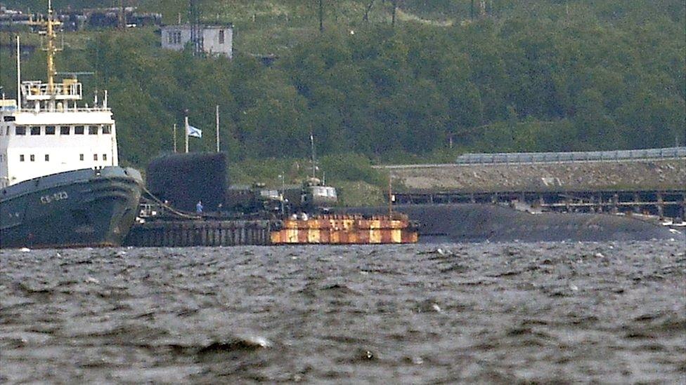 A rescue tugboat (L) and the BS-136 Orenburg ballistic missile submarine (R) carrying a nuclear deepwater station of Project 10831 at the Russian Northern Fleet's base