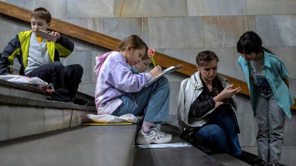 Students attend a lesson inside a Kyiv metro station during an air raid alert