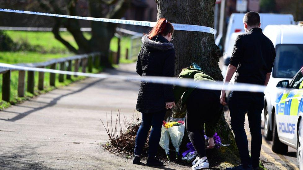 People laying flowers at the crime scene