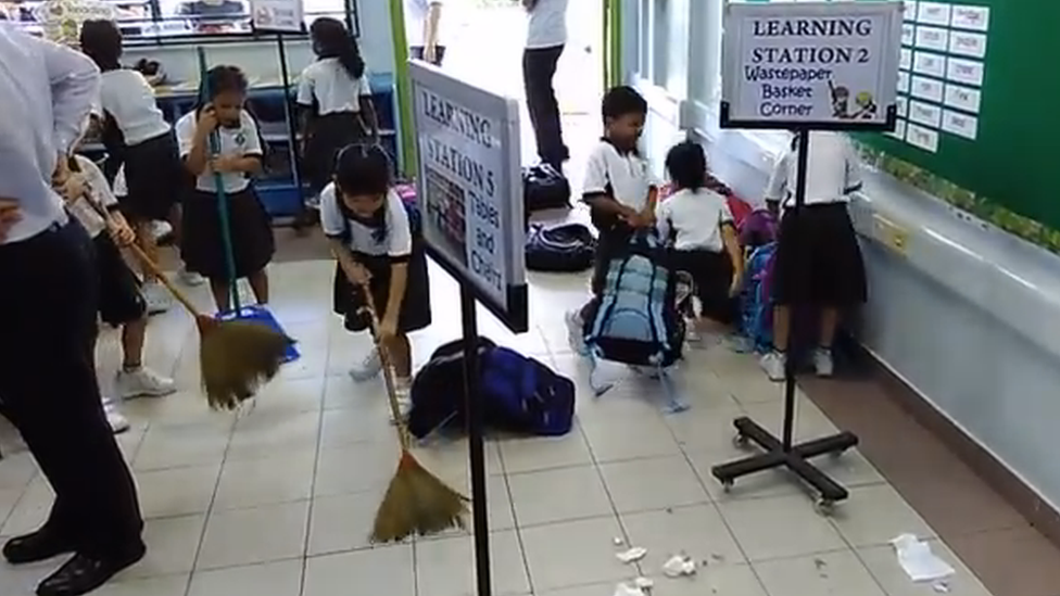 Singapore primary school pupils sweeping in a classroom