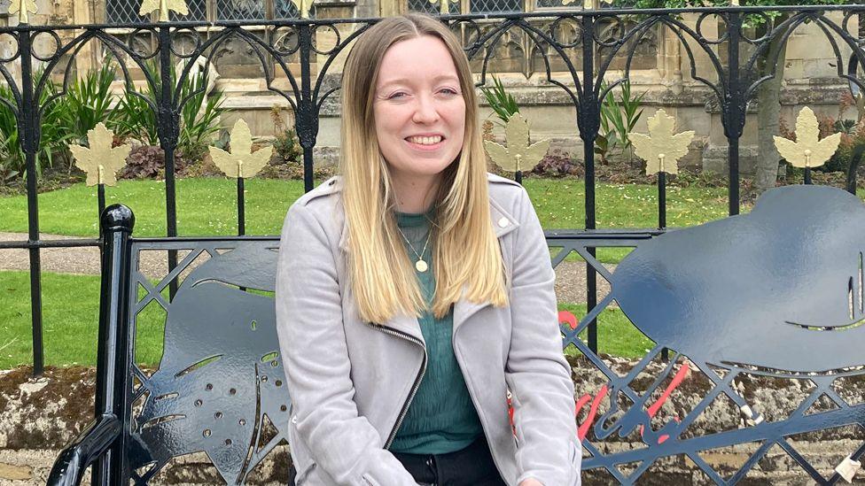 Georgie Hunt sitting on a bench 