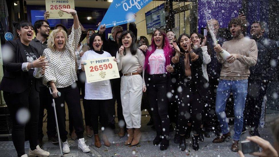 Owners and employees of the shop "Dona Manolita" celebrate selling the winning ticket.