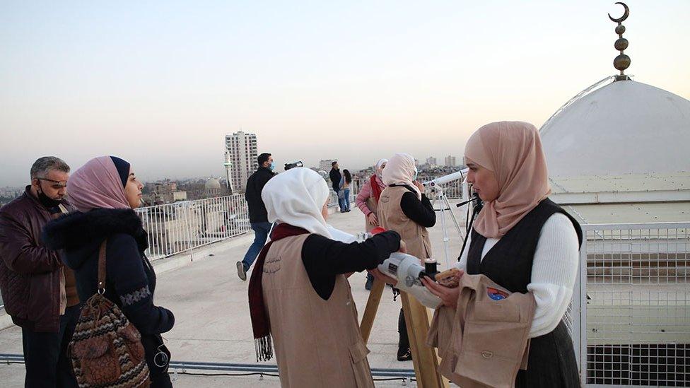 Syrians observe through telescopes