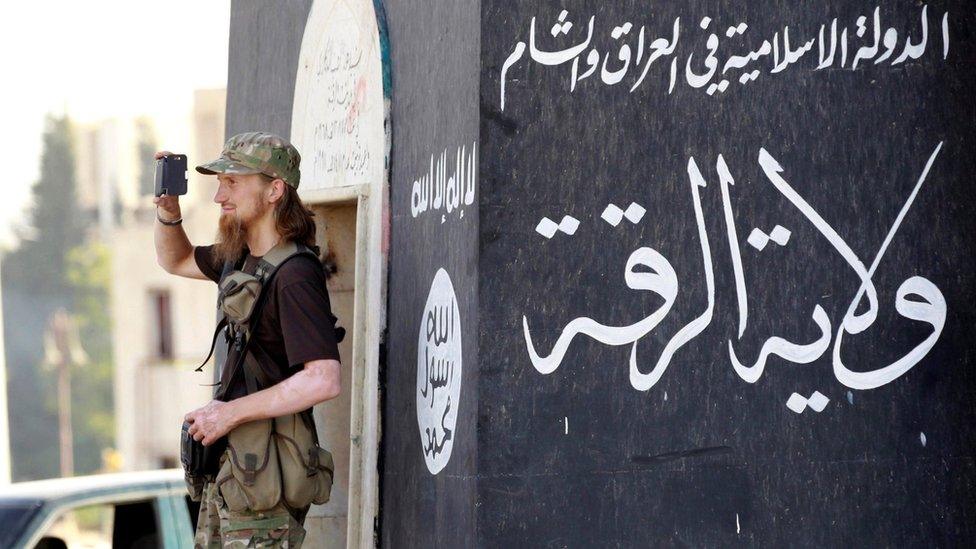 Jihadist takes a photo as IS militants celebrate in Raqqa on 30 June 2014