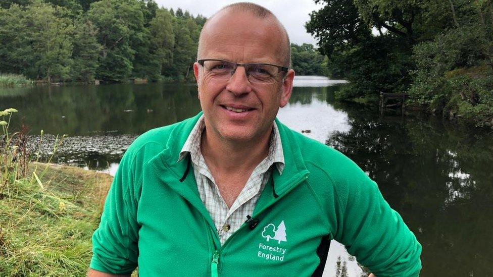 Deputy Surveyor of Forest of Dean Kevin Stannard standing with one of the ponds in the background