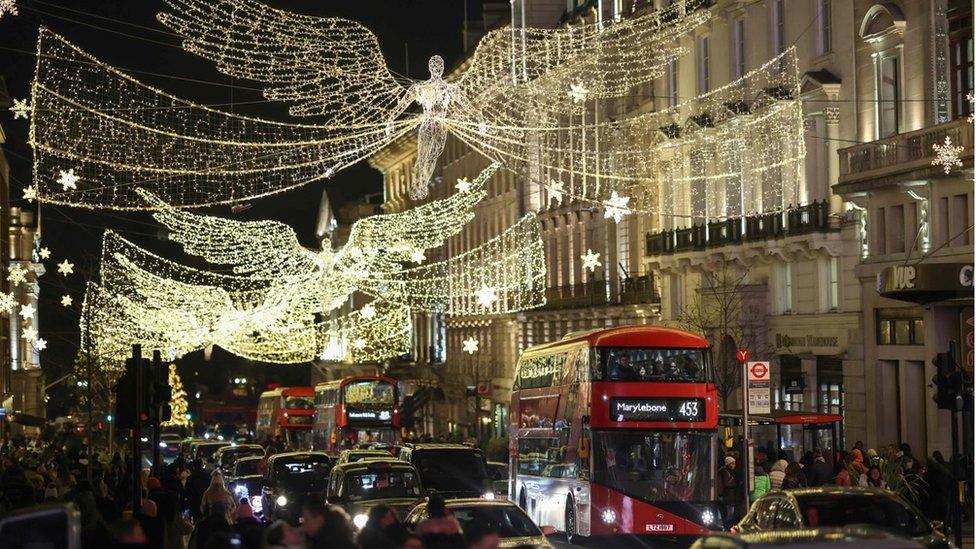 Buses pass under Christmas lights near Piccadilly Circus on December 3, 2022 in London, England.