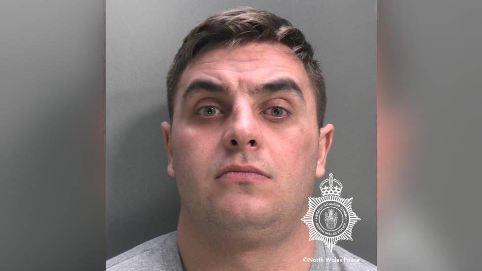 Police mugshot of Thomas Iverson. he has brown hair and stubble.