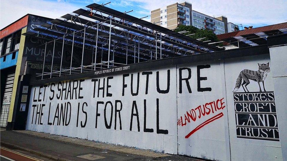 Wall saying "Let's share the future the land is for all"