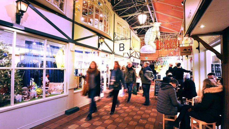 Shoppers walk down one of the avenues of the market.