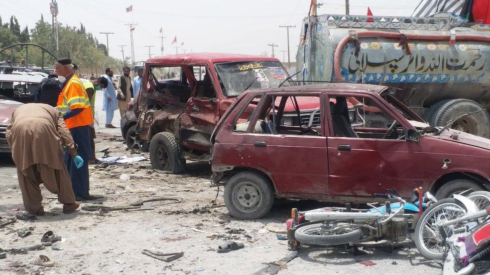 Pakistani security officials inspect the scene of a suspected suicide bomb attack outside a polling station in Quetta