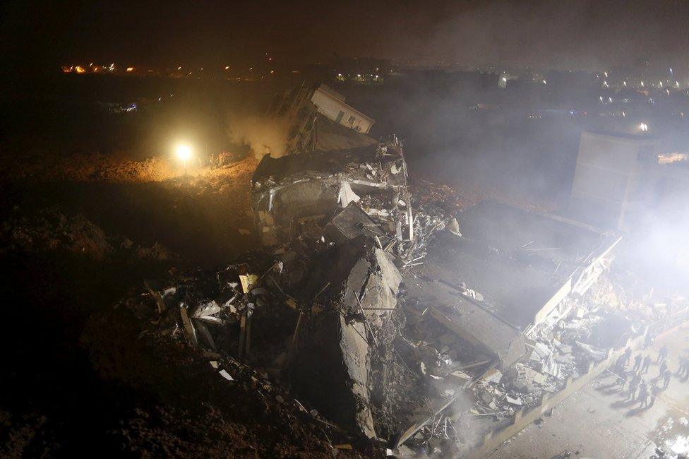 Damaged buildings are seen as rescuers search for survivors after a landslide hit an industrial park in Shenzhen, Guangdong province, China 20 December 2015