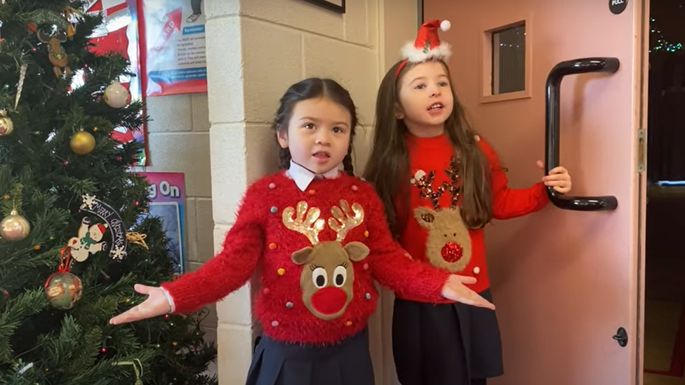 Two pupils dressed in Christmas jumpers