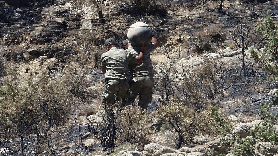 Turkish Cypriot military personnel carry debris from a suspected stray Russian-made S-200 anti-aircraft missile fired by Syria (1 July 2019)