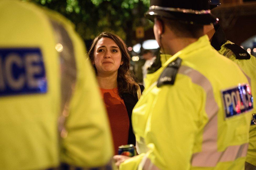 A tearful woman thanks police officers for all of their work following an evening vigil outside the Town Hall in Manchester, 23 May