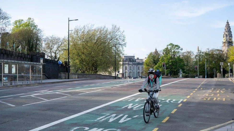 Food delivery cyclist wearing mask in Cardiff